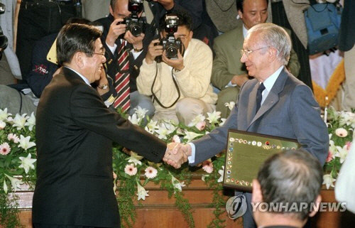 1996년 4월 23일 서울 올림픽회관에서 열린 대한올림픽위원회(KOC) 창립 50주년 기념식에서 김운용(왼쪽) 위원장이 후안 안토니오 사마란치 IOC 위원장에게 기념패를 전달하는 모습.   [연합뉴스]